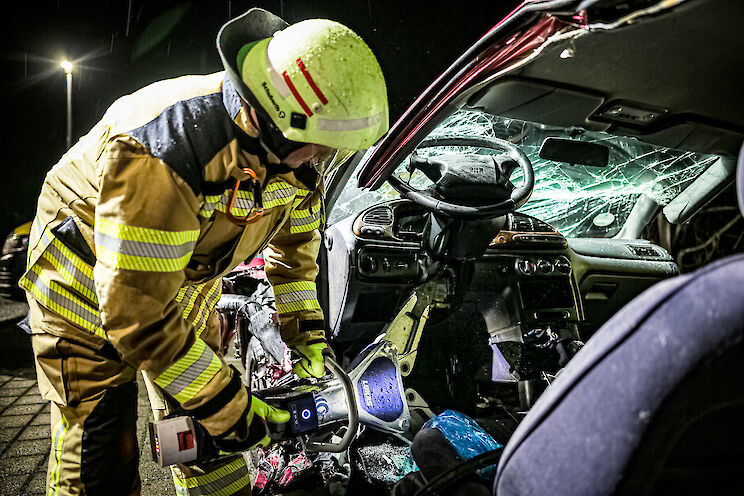 Ein Feuerwehrmann wendet einen hydraulischen Rettungsspreizer an einem Unfallfahrzeug an.
